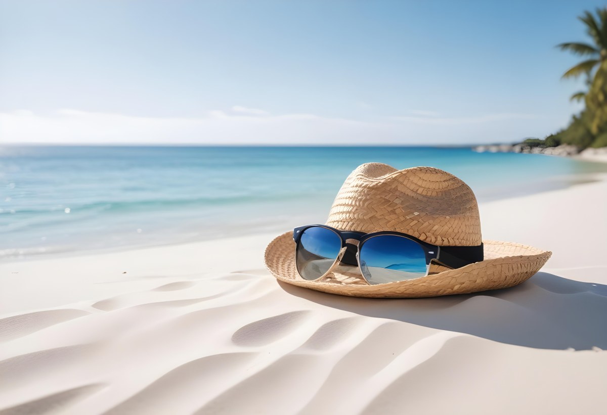 Straw Hat And Sunglasses On A White Sand Beach With A Clear Blue Sky And Ocean In The Background 38 9de0
