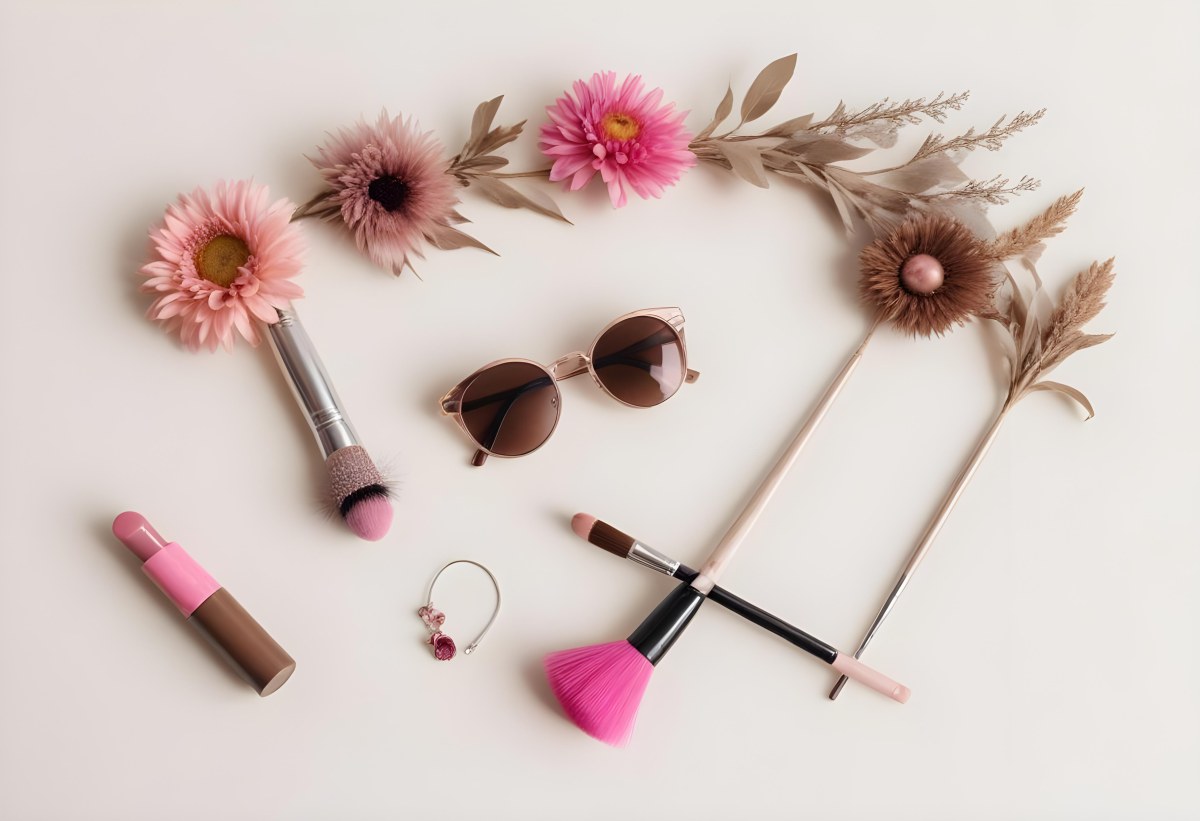 Sunglasses With Brown Lenses A Pink Hairband Pink Lipstick A Brown Lipstick Pink Nail Polish A Round Makeup Brush Small Silver Earrings Dried Flowers And False Eyelashes Arranged On A Light Colored Surface 7 6385