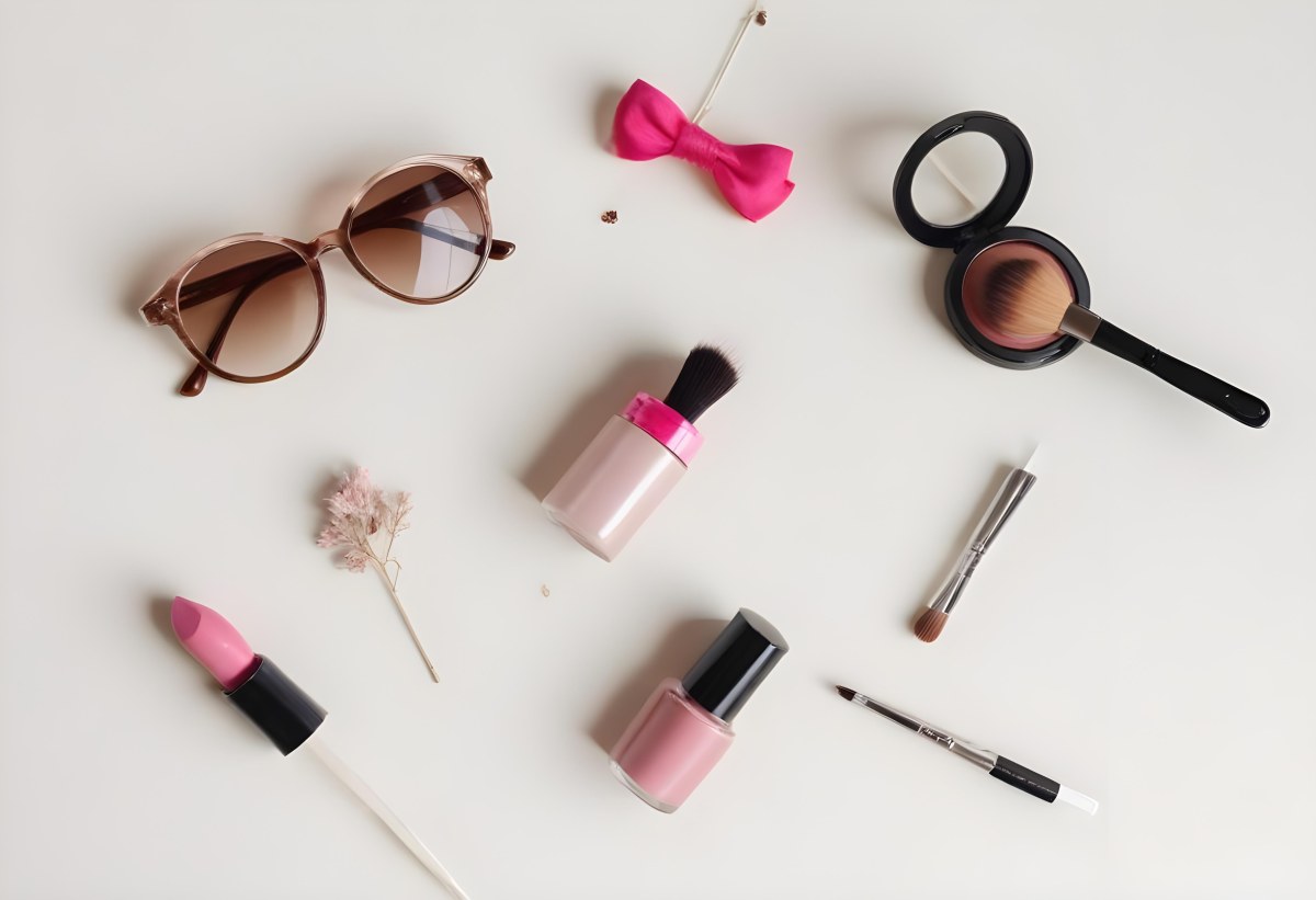 Sunglasses With Brown Lenses A Pink Hairband Pink Lipstick A Brown Lipstick Pink Nail Polish A Round Makeup Brush Small Silver Earrings Dried Flowers And False Eyelashes Arranged On A Light Colored Surface 8 C1e4