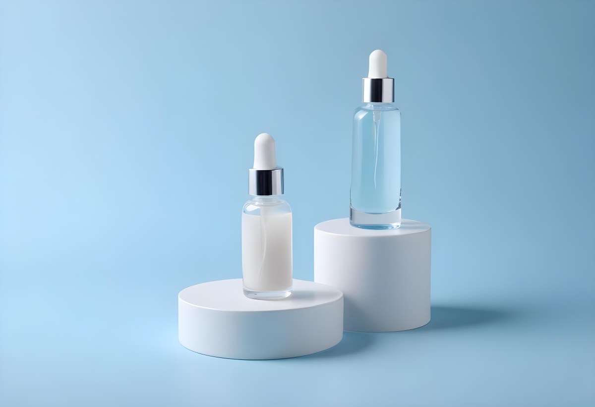 Two Cosmetic Bottles With Droppers One With A Blue Liquid And The Other Transparent On Top Of White Platforms With A Light Blue Background 40 820b