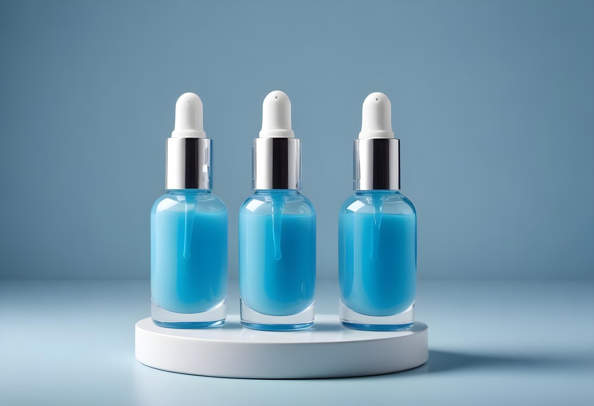 Two Cosmetic Bottles With Droppers One With A Blue Liquid And The Other Transparent On Top Of White Platforms With A Light Blue Background 43 449d