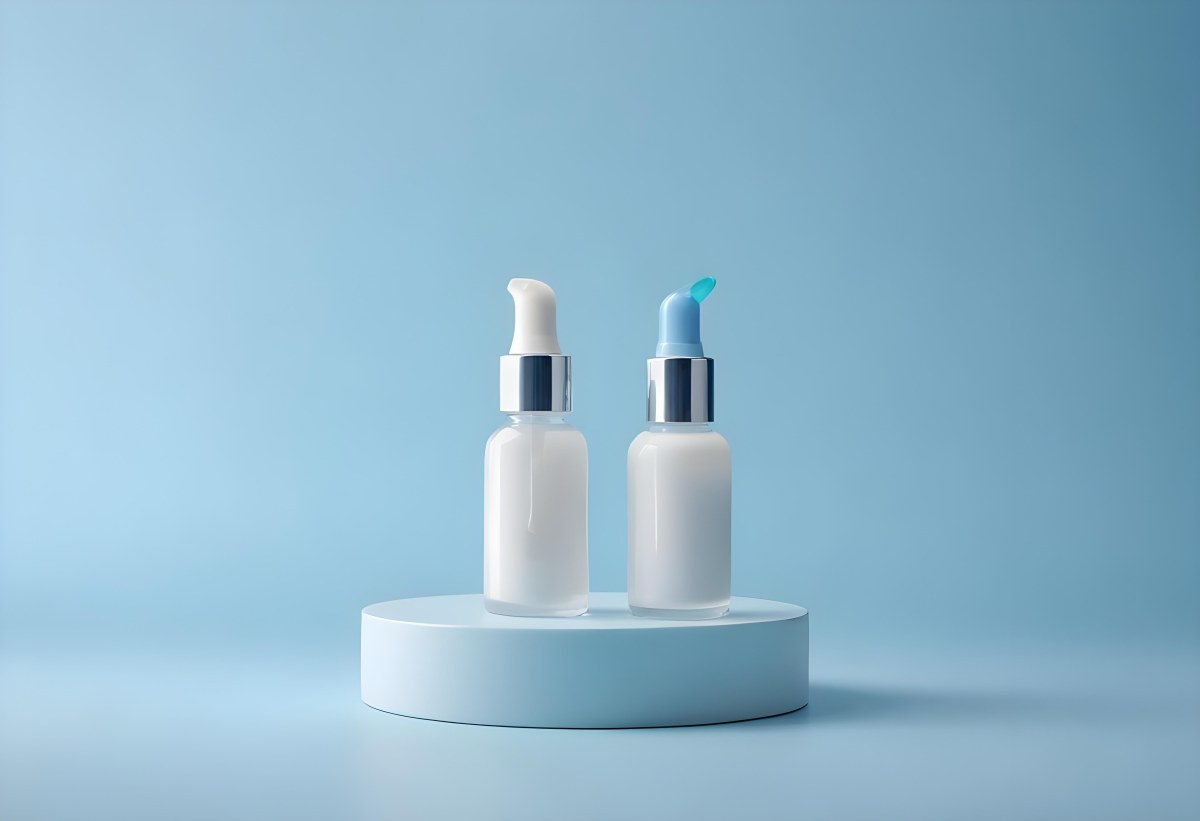 Two Cosmetic Bottles With Droppers One With A Blue Liquid And The Other Transparent On Top Of White Platforms With A Light Blue Background 46 2ad2