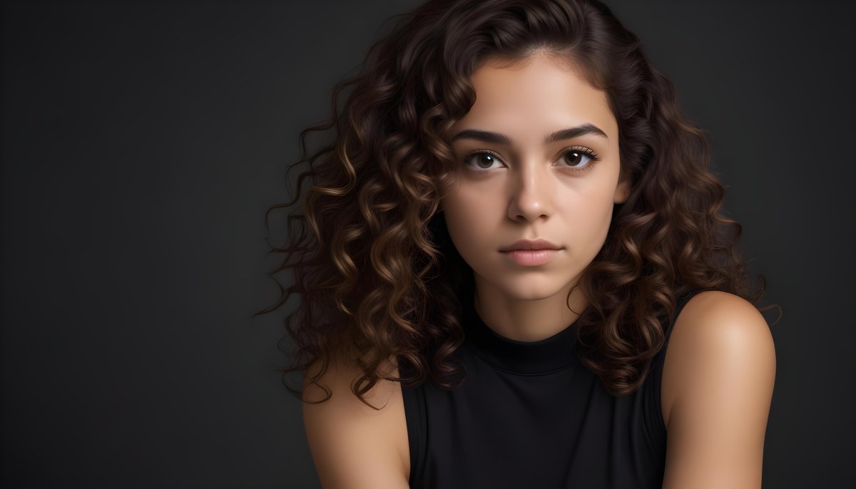 Young Woman With Medium Skin Tone And Long Curly Brown Hair Wearing A Black Sleeveless Top Looking Directly At The Camera With A Neutral Expression The Background Is Dark And Simple Emphasizing Her Features 46 158b