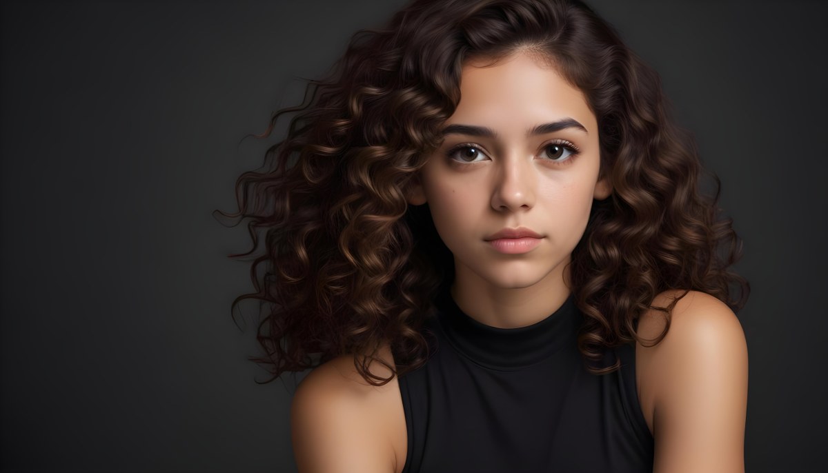 Young Woman With Medium Skin Tone And Long Curly Brown Hair Wearing A Black Sleeveless Top Looking Directly At The Camera With A Neutral Expression The Background Is Dark And Simple Emphasizing Her Features 58 0442