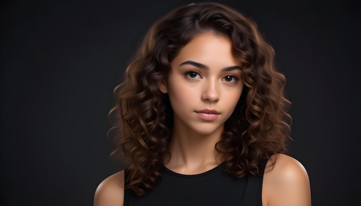 Young Woman With Medium Skin Tone And Long Curly Brown Hair Wearing A Black Sleeveless Top Looking Directly At The Camera With A Neutral Expression The Background Is Dark And Simple Emphasizing Her Features 6 43e9