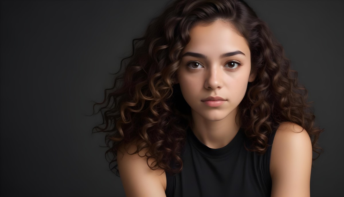 Young Woman With Medium Skin Tone And Long Curly Brown Hair Wearing A Black Sleeveless Top Looking Directly At The Camera With A Neutral Expression The Background Is Dark And Simple Emphasizing Her Features 61 251b