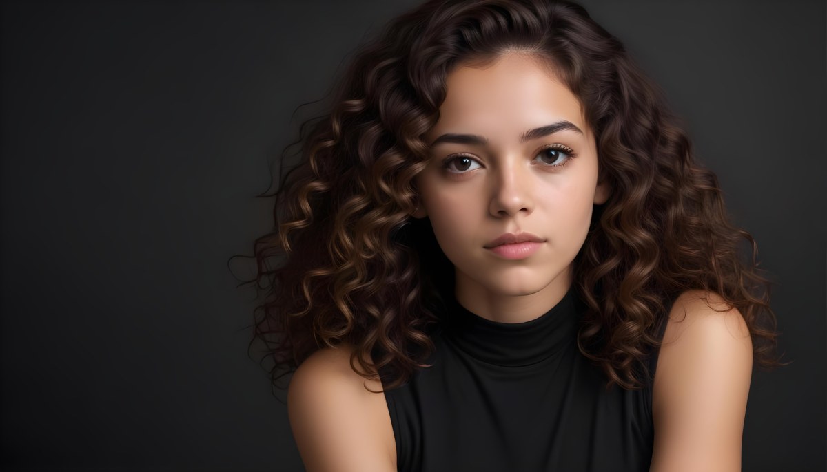 Young Woman With Medium Skin Tone And Long Curly Brown Hair Wearing A Black Sleeveless Top Looking Directly At The Camera With A Neutral Expression The Background Is Dark And Simple Emphasizing Her Features 64 8915