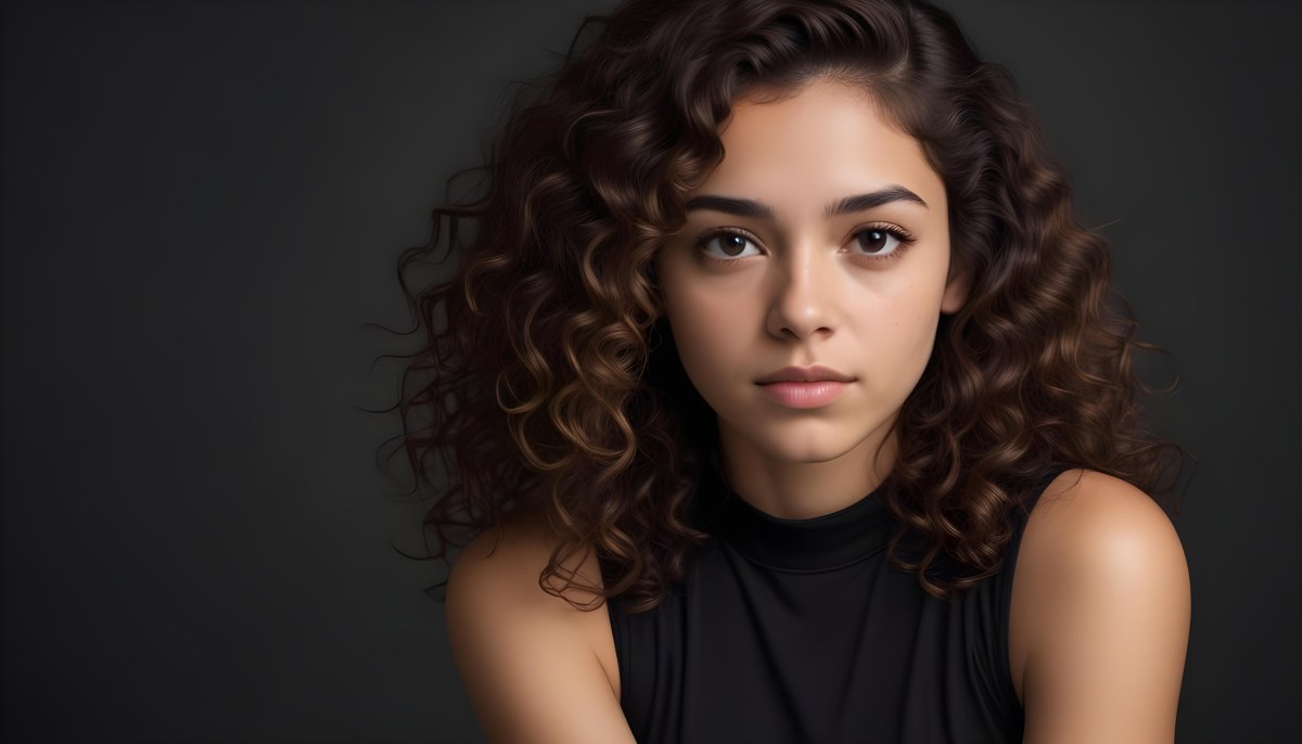 Young Woman With Medium Skin Tone And Long Curly Brown Hair Wearing A Black Sleeveless Top Looking Directly At The Camera With A Neutral Expression The Background Is Dark And Simple Emphasizing Her Features 7 24eb