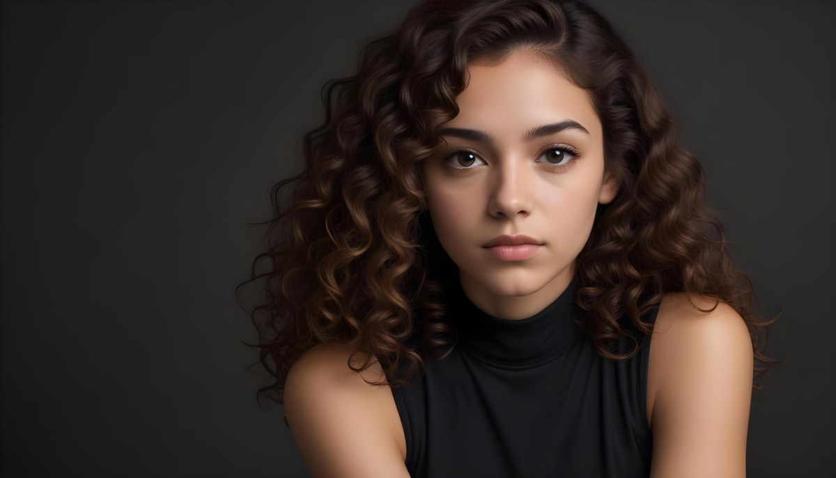 Young Woman With Medium Skin Tone And Long Curly Brown Hair Wearing A Black Sleeveless Top Looking Directly At The Camera With A Neutral Expression The Background Is Dark And Simple Emphasizing Her Features 9 E77c