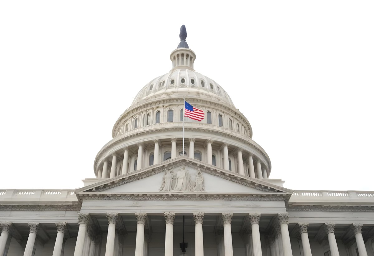The United States Capitol Building With The American Flag Waving In The Wind The Sky Is White 21 3712