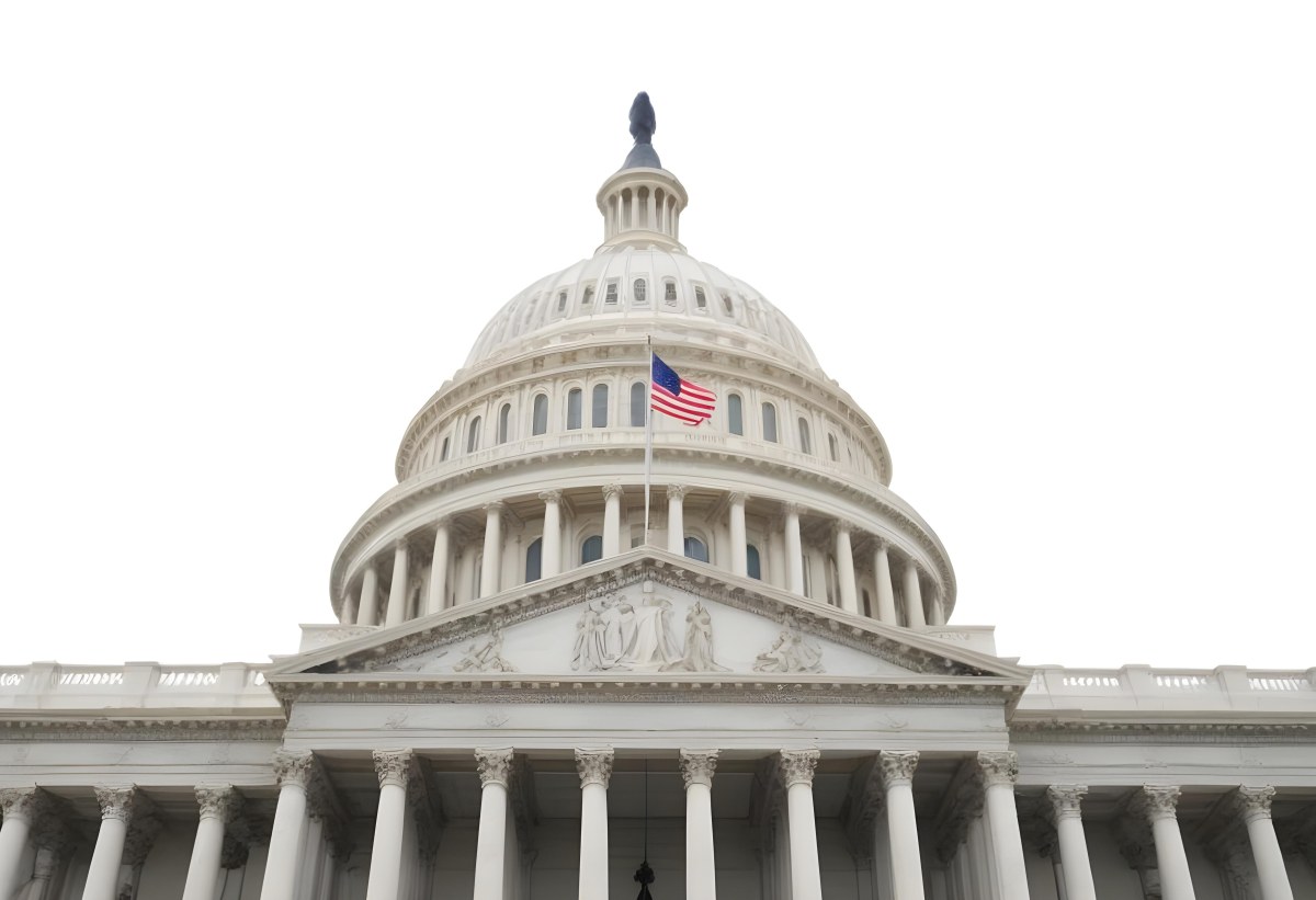 The United States Capitol Building With The American Flag Waving In The Wind The Sky Is White 3 E1b2