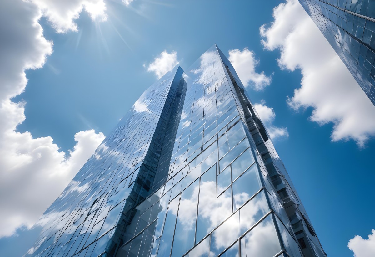 Low Angle Shot Of A Modern Glass Skyscraper Reflecting The Blue Sky And White Clouds Sun Shining Through The Clouds Creating A Bright And Airy Atmosphere 43 7f9e