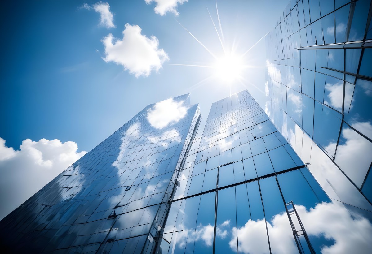 Low Angle Shot Of A Modern Glass Skyscraper Reflecting The Blue Sky And White Clouds Sun Shining Through The Clouds Creating A Bright And Airy Atmosphere 49 Dbff