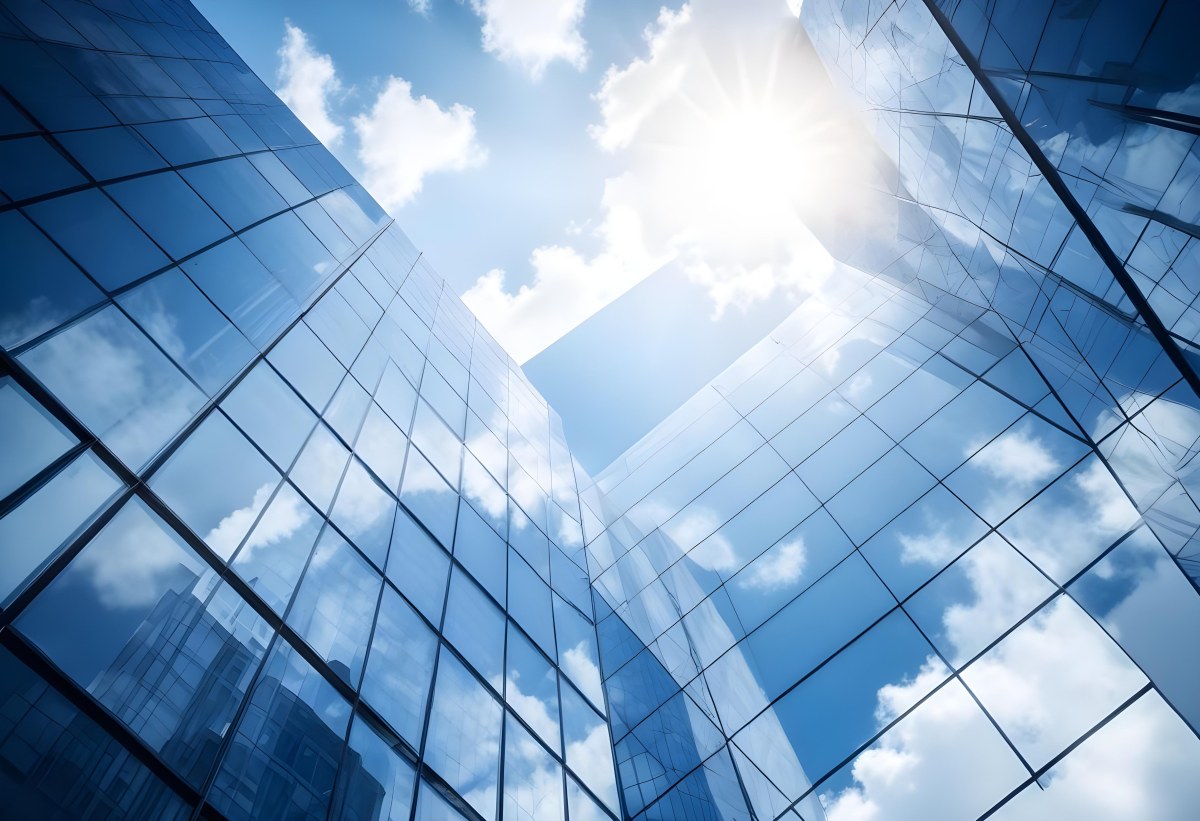 Low Angle Shot Of A Modern Glass Skyscraper Reflecting The Blue Sky And White Clouds Sun Shining Through The Clouds Creating A Bright And Airy Atmosphere 6 507c