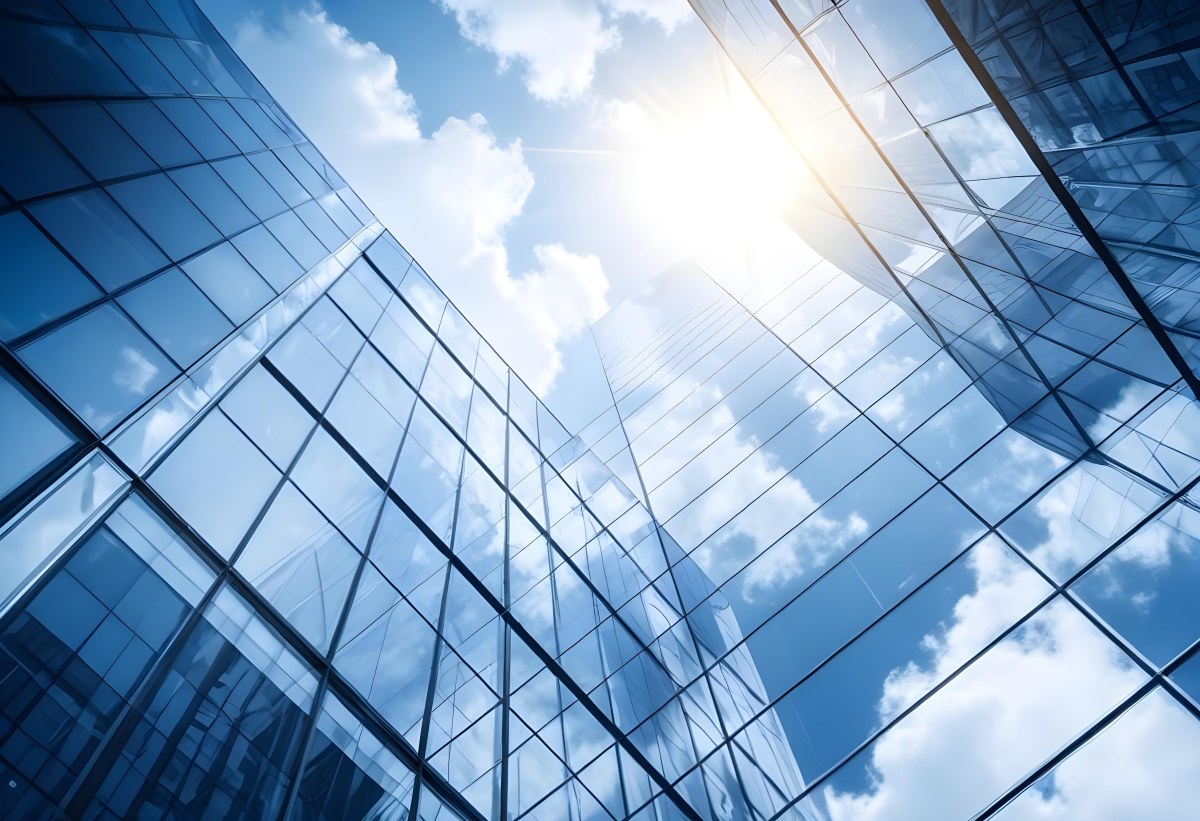 Low Angle Shot Of A Modern Glass Skyscraper Reflecting The Blue Sky And White Clouds Sun Shining Through The Clouds Creating A Bright And Airy Atmosphere 76 6ce7