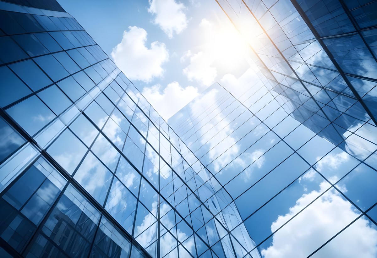 Low Angle Shot Of A Modern Glass Skyscraper Reflecting The Blue Sky And White Clouds Sun Shining Through The Clouds Creating A Bright And Airy Atmosphere 77 74f4