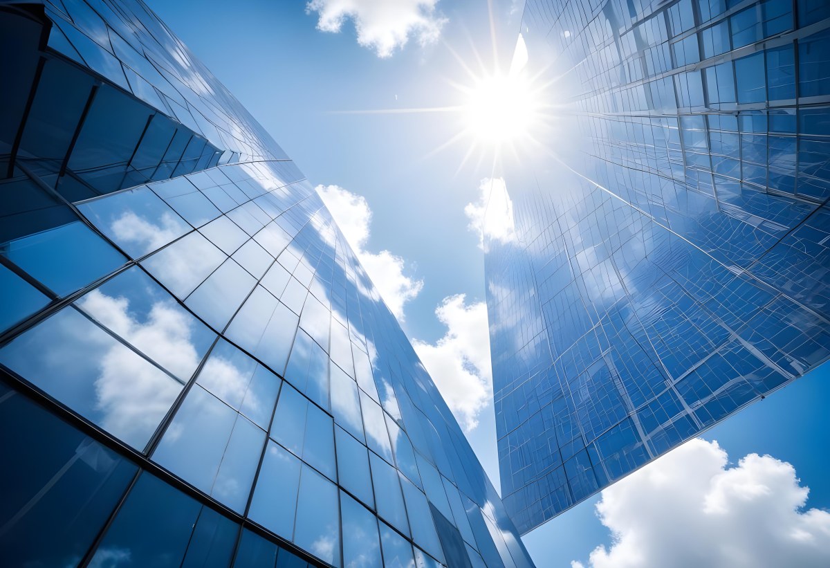 Low Angle Shot Of A Modern Glass Skyscraper Reflecting The Blue Sky And White Clouds Sun Shining Through The Clouds Creating A Bright And Airy Atmosphere 8 61cf