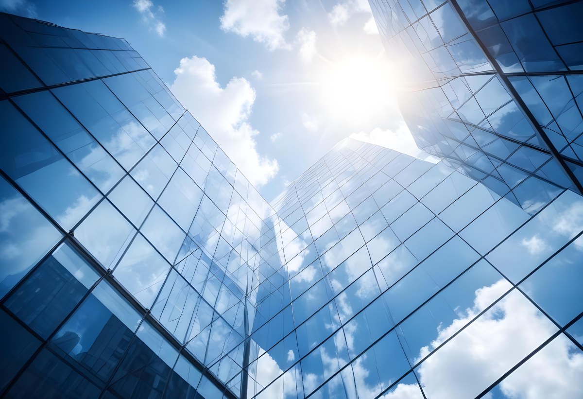 Low Angle Shot Of A Modern Glass Skyscraper Reflecting The Blue Sky And White Clouds Sun Shining Through The Clouds Creating A Bright And Airy Atmosphere 8 A7fe