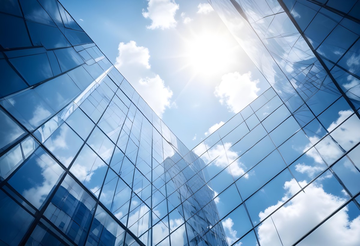 Low Angle Shot Of A Modern Glass Skyscraper Reflecting The Blue Sky And White Clouds Sun Shining Through The Clouds Creating A Bright And Airy Atmosphere 83 76ea