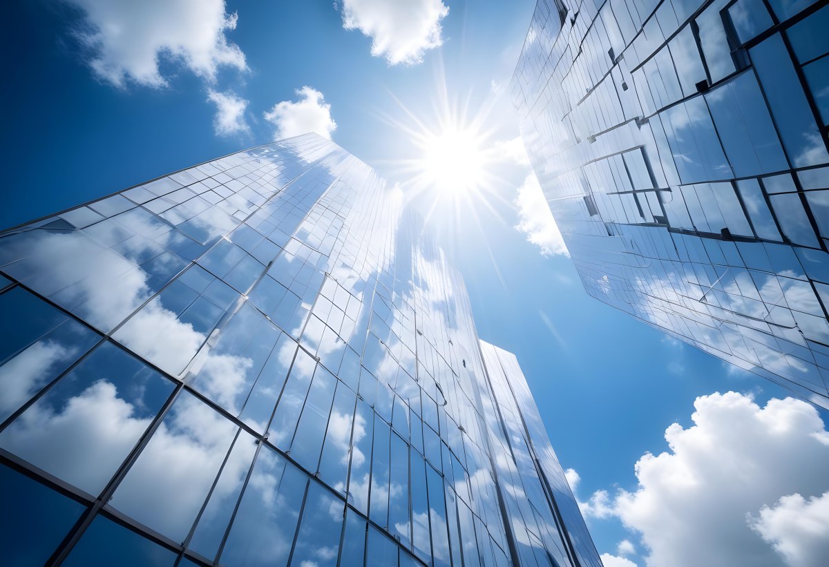 Low Angle Shot Of A Modern Glass Skyscraper Reflecting The Blue Sky And White Clouds Sun Shining Through The Clouds Creating A Bright And Airy Atmosphere 9 588f
