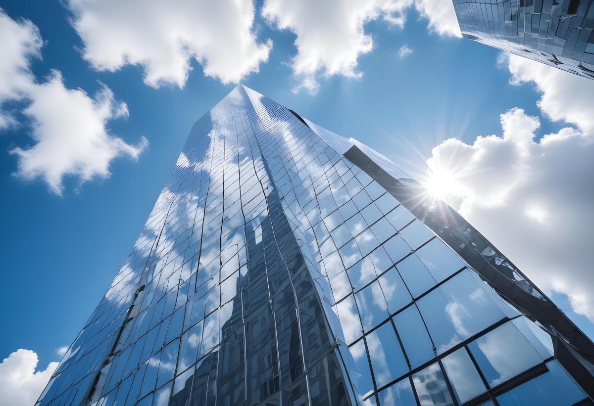 Low Angle Shot Of A Modern Glass Skyscraper Reflecting The Blue Sky And White Clouds Sun Shining Through The Clouds Creating A Bright And Airy Atmosphere 9 Ad9c