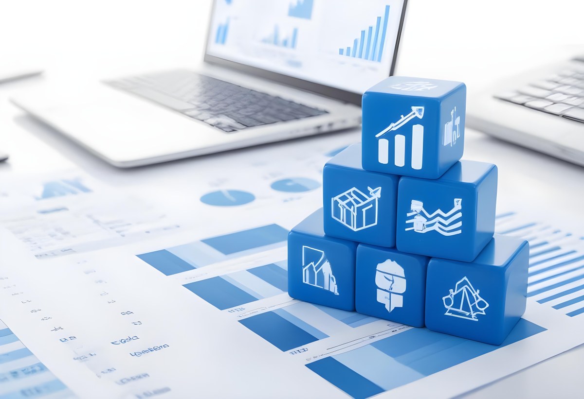 Stack Of Blue Cubes With Business Icons On Top Of A Financial Report With A Laptop In The Background 1 D74d