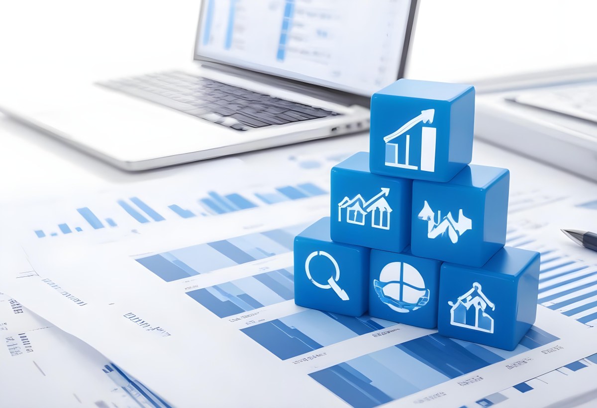 Stack Of Blue Cubes With Business Icons On Top Of A Financial Report With A Laptop In The Background 24 5416
