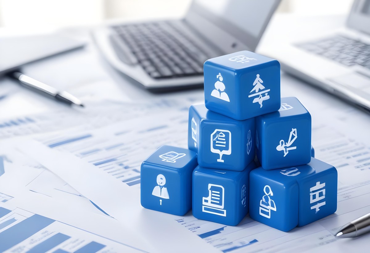 Stack Of Blue Cubes With Business Icons On Top Of A Financial Report With A Laptop In The Background 31 Dac2