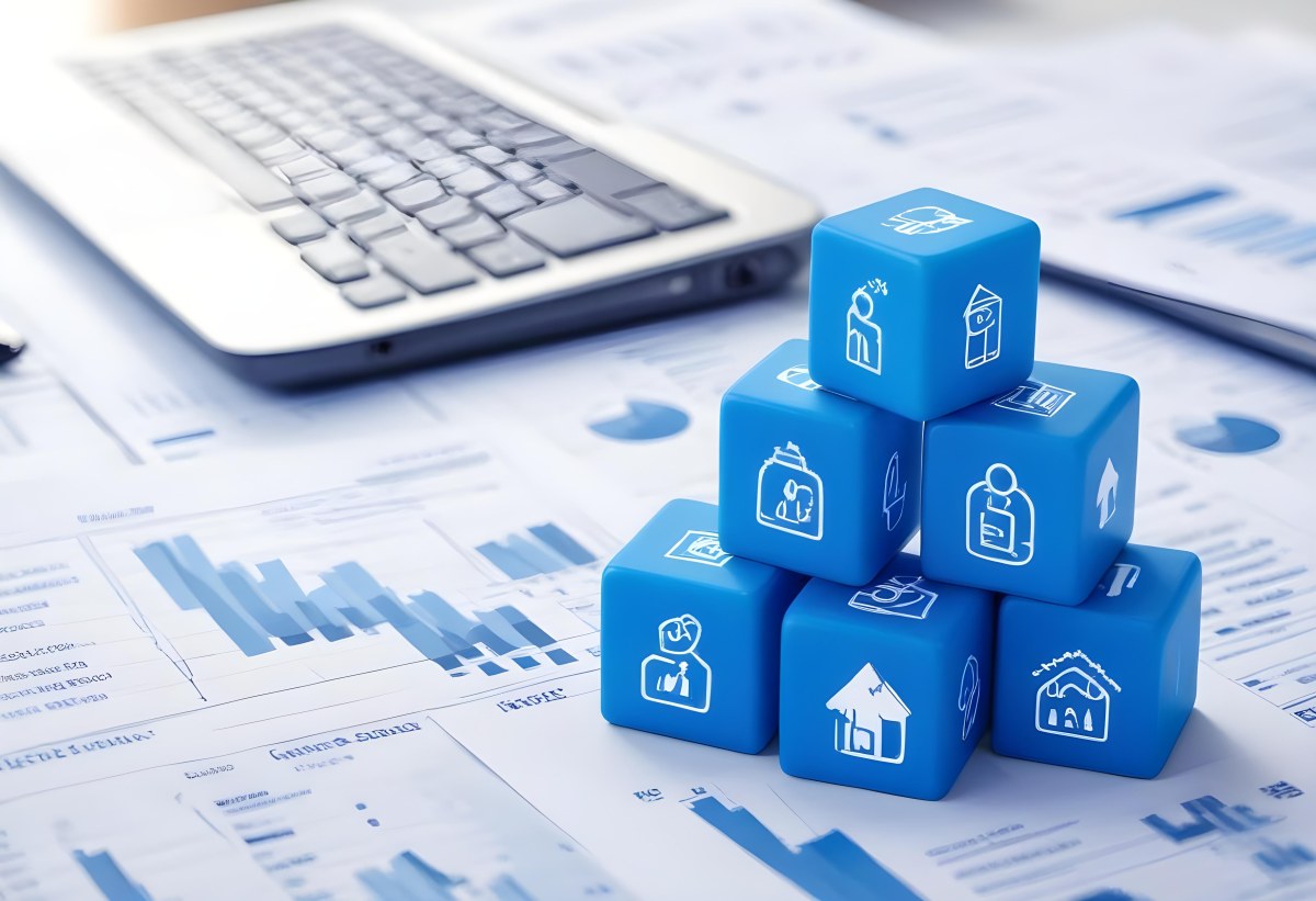 Stack Of Blue Cubes With Business Icons On Top Of A Financial Report With A Laptop In The Background 4 C749