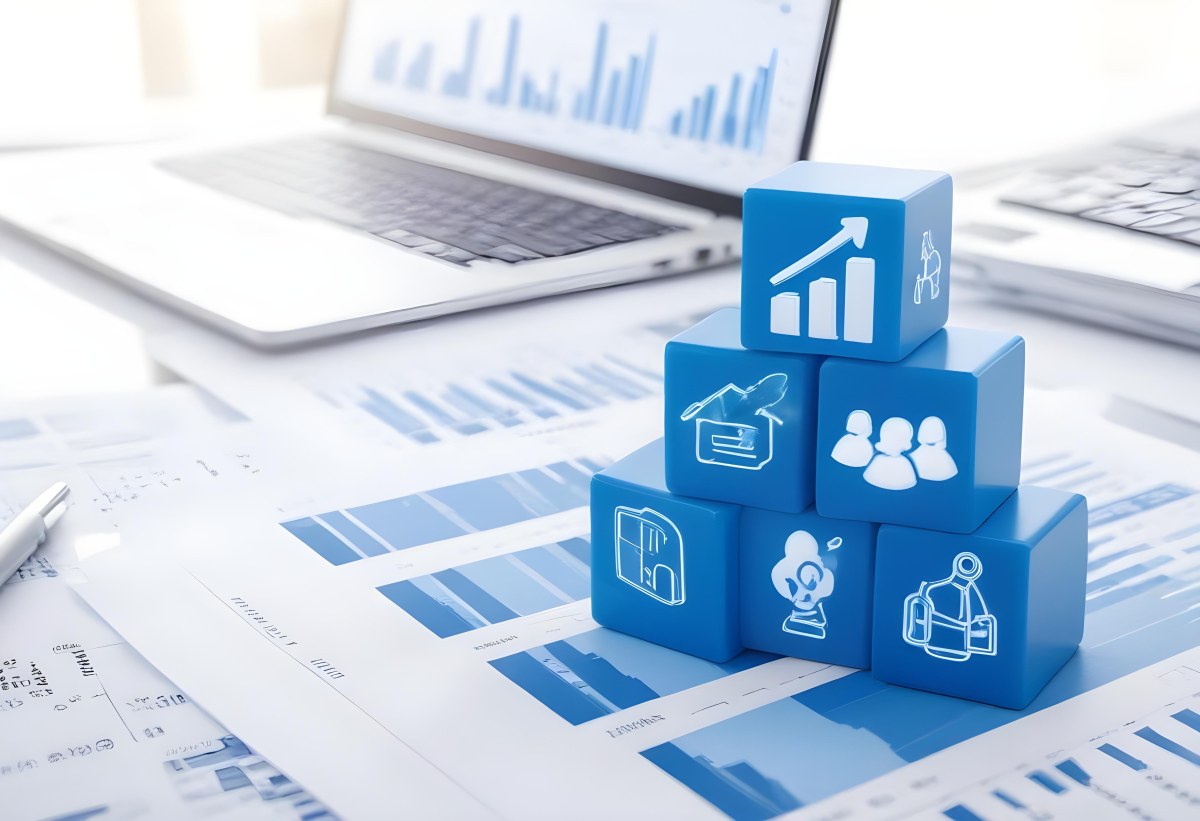 Stack Of Blue Cubes With Business Icons On Top Of A Financial Report With A Laptop In The Background 5 6ea9