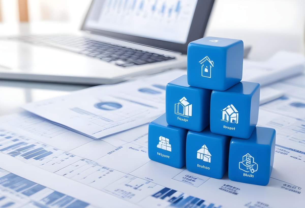 Stack Of Blue Cubes With Business Icons On Top Of A Financial Report With A Laptop In The Background 6 9535