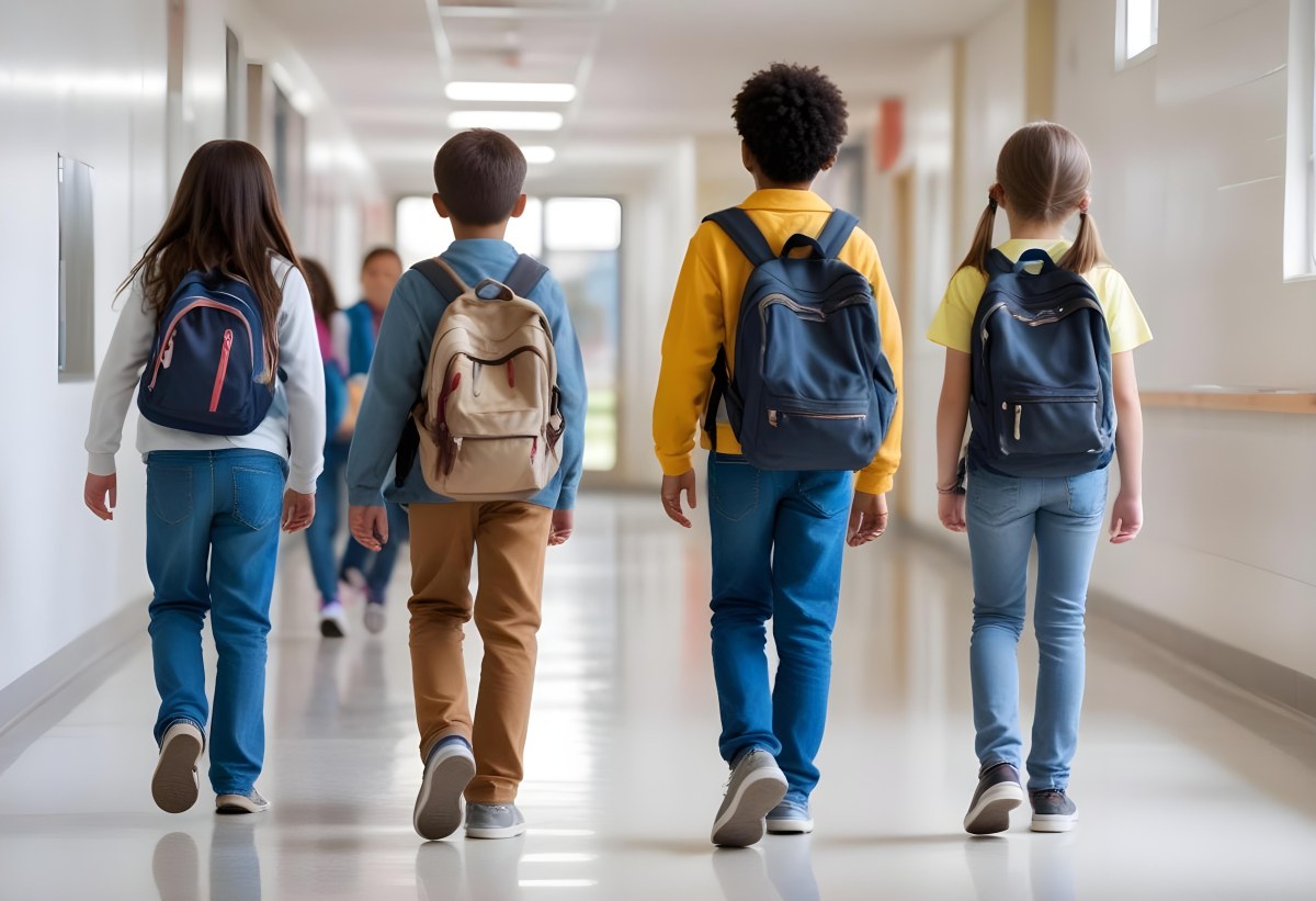 A Group Of Elementary School Students Walking Down A School Hallway Carrying Backpacks The Students Appear To Be A Mix Of Races With Both Boys And Girls And Are Wearing Casual Clothing Like Jeans And T Shirts 5 9e2a