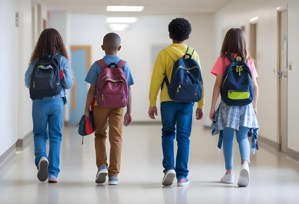 A Group Of Elementary School Students Walking Down A School Hallway Carrying Backpacks The Students Appear To Be A Mix Of Races With Both Boys And Girls And Are Wearing Casual Clothing Like Jeans And T Shirts 6 A74e