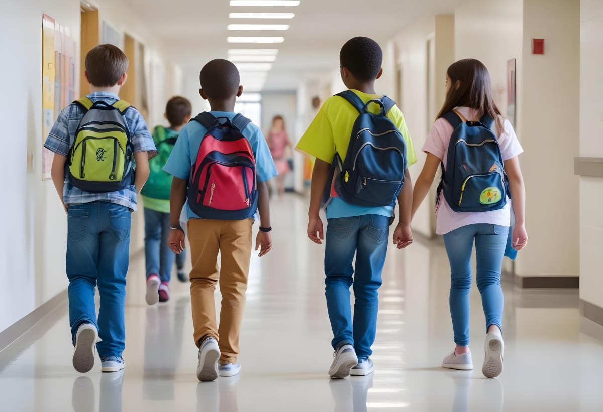 A Group Of Elementary School Students Walking Down A School Hallway Carrying Backpacks The Students Appear To Be A Mix Of Races With Both Boys And Girls And Are Wearing Casual Clothing Like Jeans And T Shirts 7 52b1