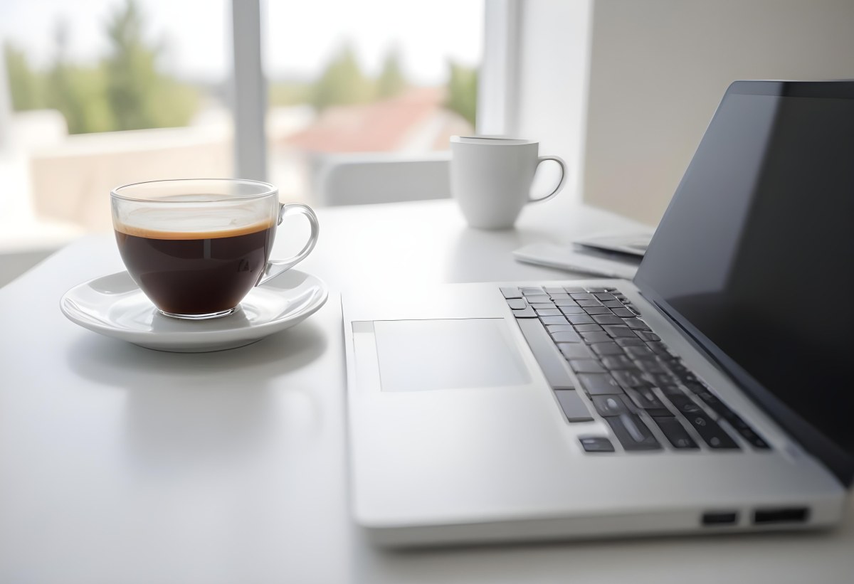 A Laptop And A Cup Of Coffee On A White Table In A Bright Environment With A Blurred Background 32 C2b9