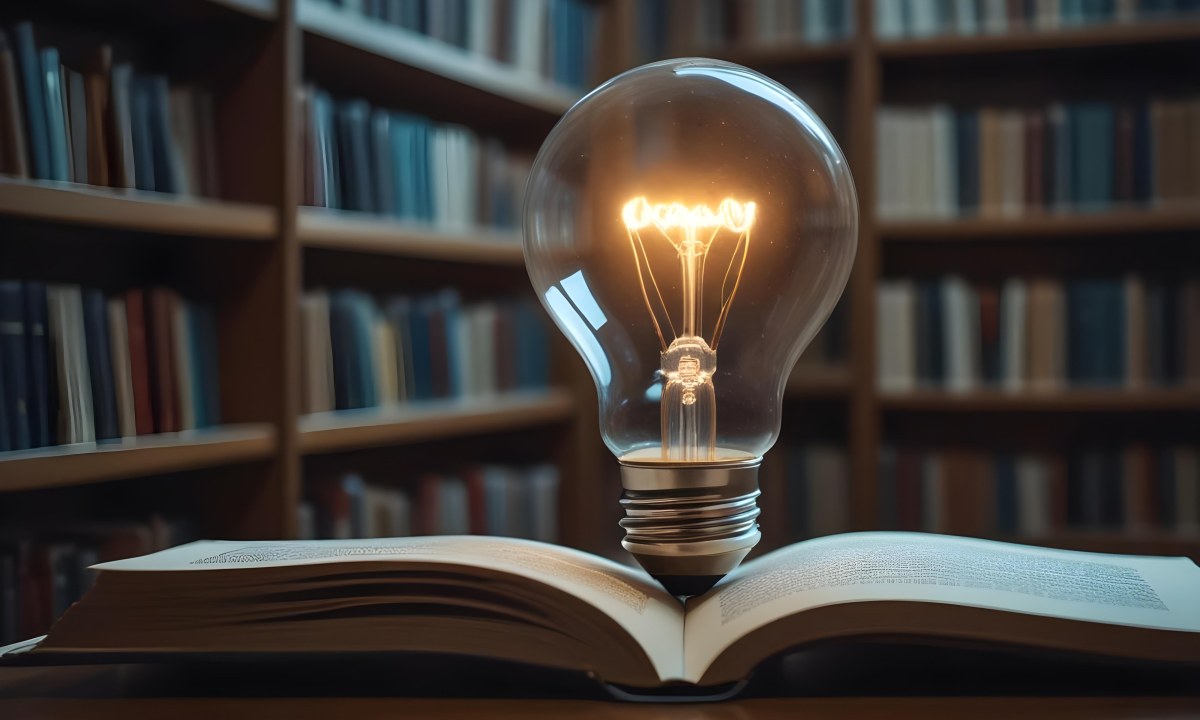 A Light Bulb On Top Of An Open Book Library In The Background With Many Books On The Shelves Warm Light Knowledge Concept 12 9ba3