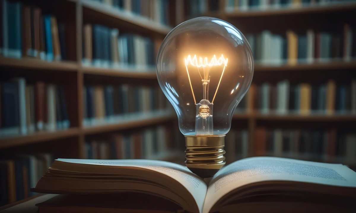 A Light Bulb On Top Of An Open Book Library In The Background With Many Books On The Shelves Warm Light Knowledge Concept 15 B7e3