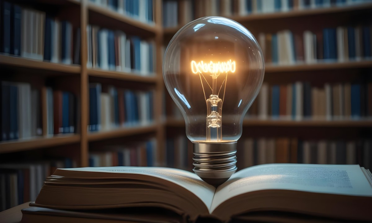 A Light Bulb On Top Of An Open Book Library In The Background With Many Books On The Shelves Warm Light Knowledge Concept 5 337e