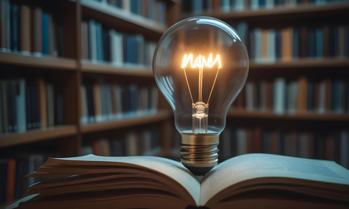 A Light Bulb On Top Of An Open Book Library In The Background With Many Books On The Shelves Warm Light Knowledge Concept 7 D61c