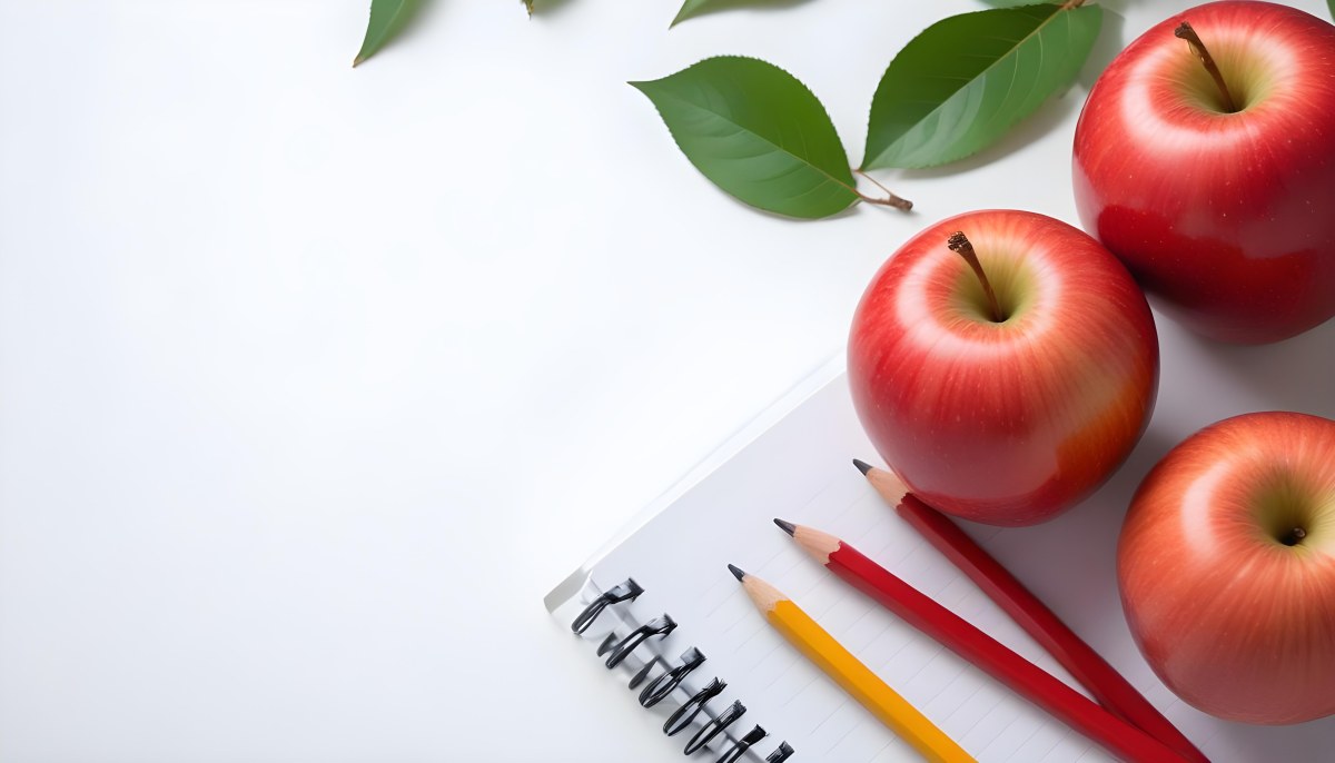 A Red Apple Pencils And A Notebook On A White Background With Green Leaves 4 1c7a