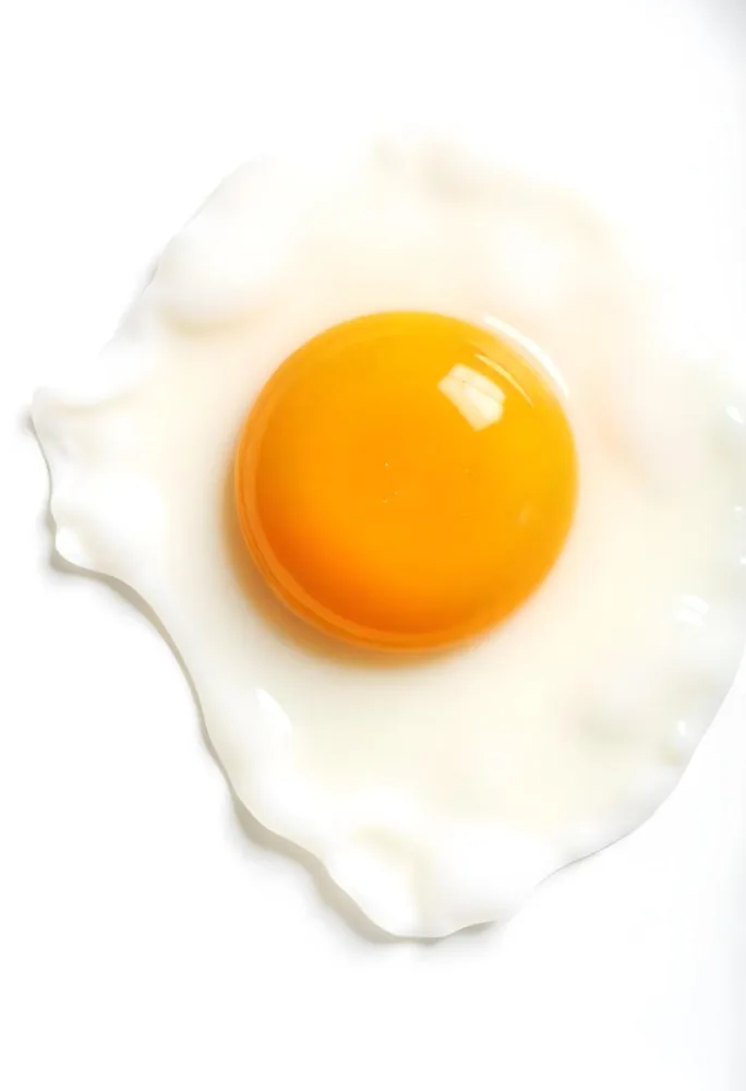 A Fried Egg With A Bright Yellow Yolk And Translucent White On A White Surface Top Down View Studio Lighting Food Photography 7 C9fd