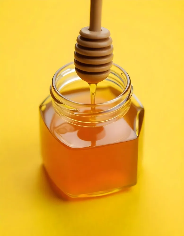 A Jar Full Of Honey With A Honey Dipper On A Yellow Background 13 0f29