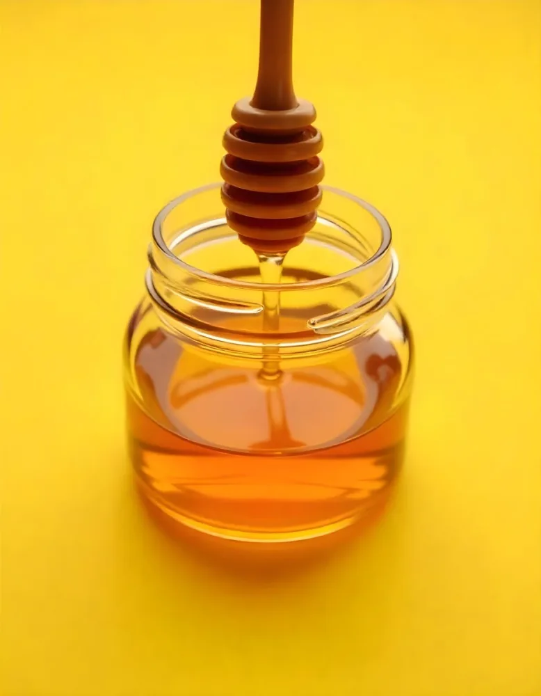 A Jar Full Of Honey With A Honey Dipper On A Yellow Background 21 F9bd
