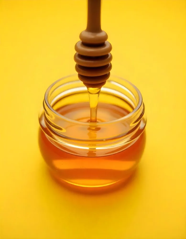 A Jar Full Of Honey With A Honey Dipper On A Yellow Background 23 831f
