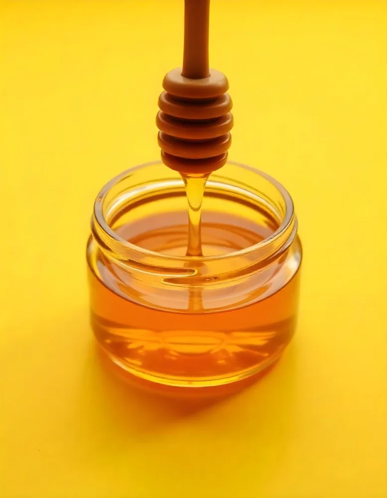 A Jar Full Of Honey With A Honey Dipper On A Yellow Background 26 A71d