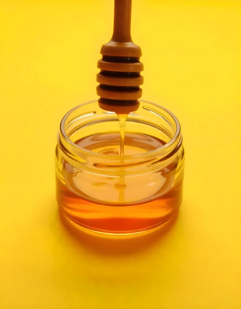 A Jar Full Of Honey With A Honey Dipper On A Yellow Background 27 63fa