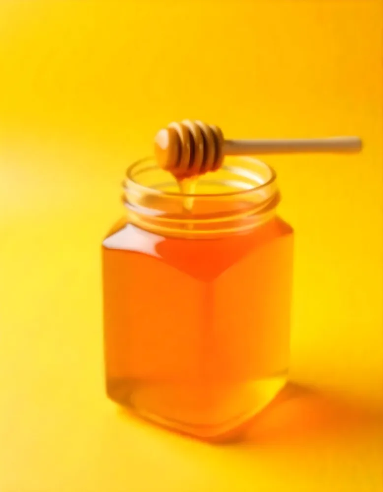 A Jar Full Of Honey With A Honey Dipper On A Yellow Background 4 5831