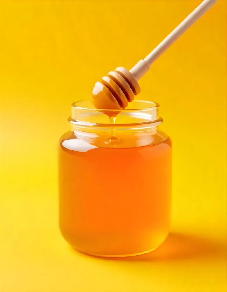 A Jar Full Of Honey With A Honey Dipper On A Yellow Background 6 F9a8