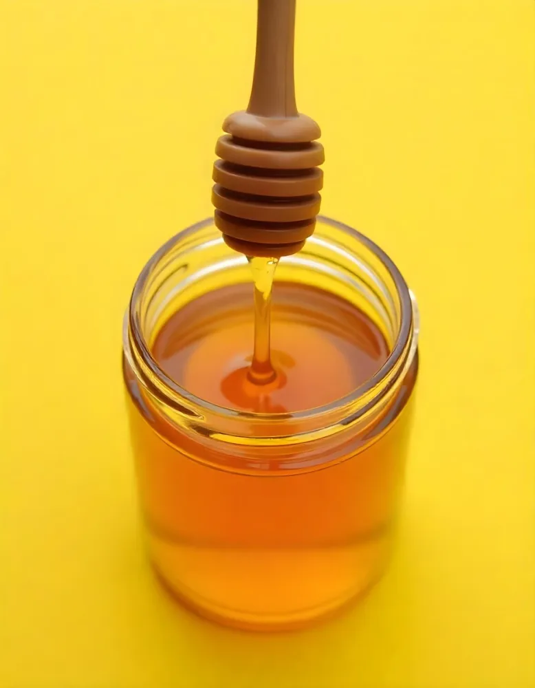 A Jar Full Of Honey With A Honey Dipper On A Yellow Background 7 Eecf