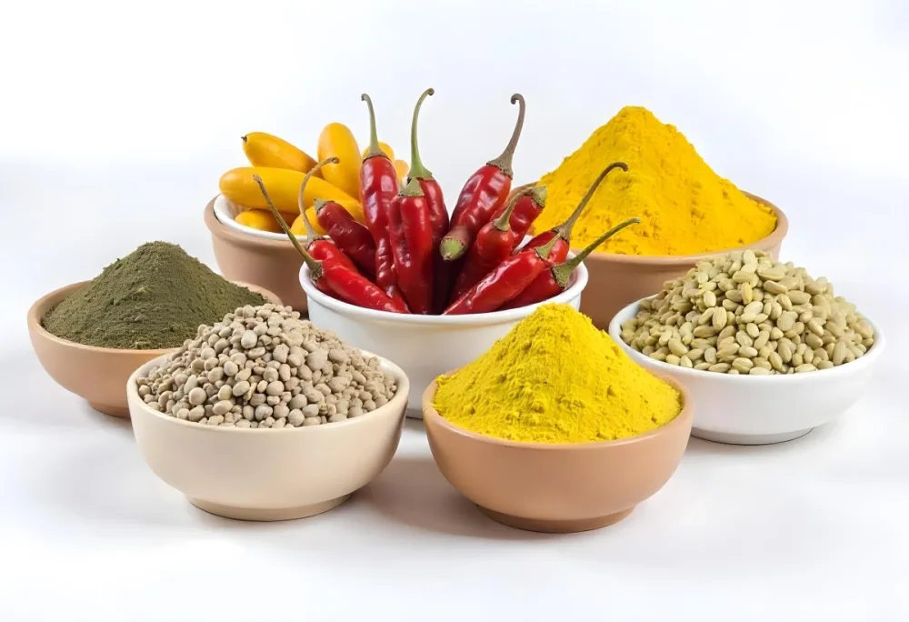 Bowls Of Spices Including Turmeric Chili Peppers Cumin Coriander And Other Ingredients Arranged On A White Surface Creating A Vibrant And Colorful Display Of Culinary Ingredients 5 70e5